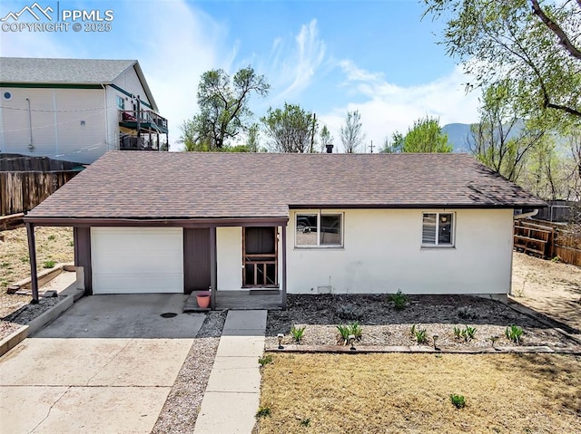 627 E Las Animas St, Colorado Springs, CO 80903 - ranch-style home with concrete driveway, fence, a garage, stucco siding, and roof with shingles