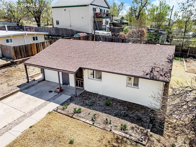 627 E Las Animas St, Colorado Springs, CO 80903 - view of front facade featuring a fenced backyard, a shingled roof, stucco siding, driveway, and a garage