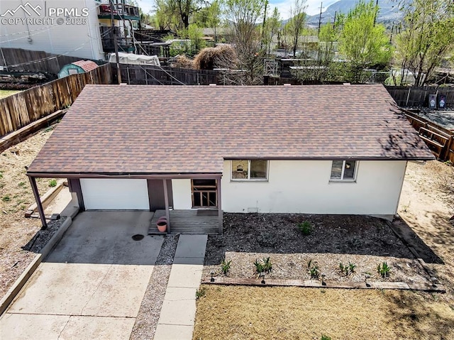 627 E Las Animas St, Colorado Springs, CO 80903 - view of front of house featuring an attached garage, a shingled roof, stucco siding, and driveway