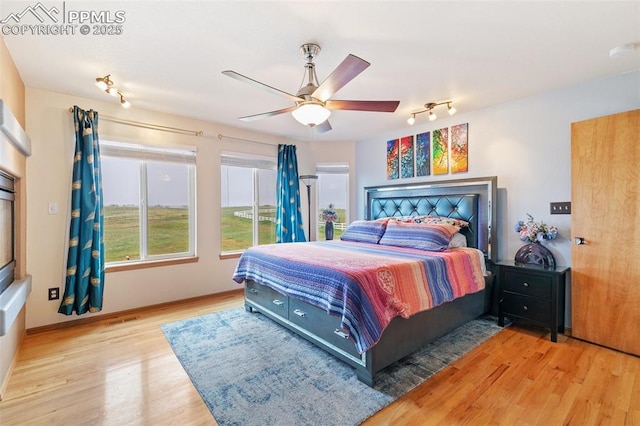11960 S Conestoga Trl, Elbert, CO 80106 - bedroom with wood finished floors, track lighting, a ceiling fan, and baseboards