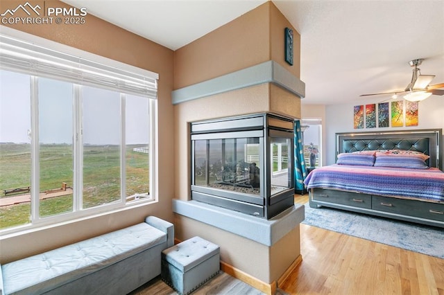 11960 S Conestoga Trl, Elbert, CO 80106 - bedroom with wood finished floors, multiple windows, and ceiling fan