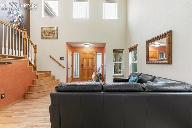11960 S Conestoga Trl, Elbert, CO 80106 - living area with a towering ceiling, wood finished floors, and stairway