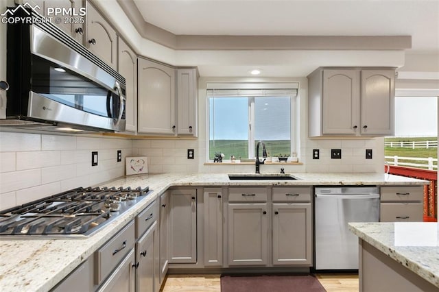 11960 S Conestoga Trl, Elbert, CO 80106 - kitchen with appliances with stainless steel finishes, a sink, gray cabinets, and backsplash