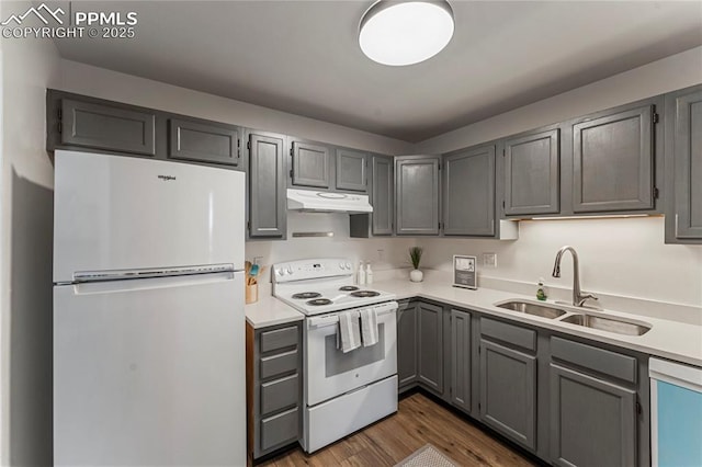 kitchen with a sink, freestanding refrigerator, dishwasher, under cabinet range hood, and white range with electric cooktop