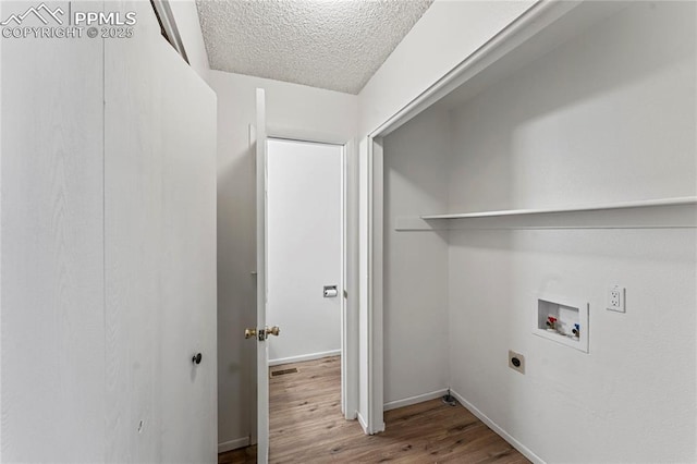laundry room featuring a textured ceiling, baseboards, hookup for a washing machine, wood finished floors, and electric dryer hookup