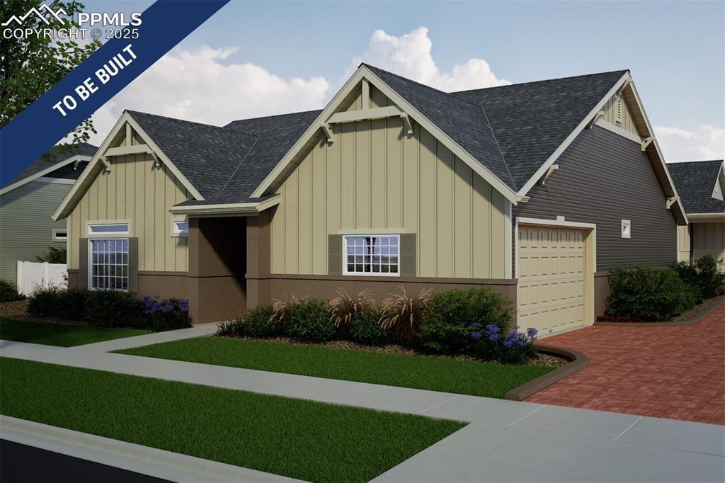5807 Mireland Vw, Colorado Springs, CO 80927 - view of front of home with decorative driveway, board and batten siding, a shingled roof, and a garage