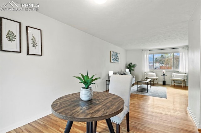 dining area featuring baseboards and light wood finished floors