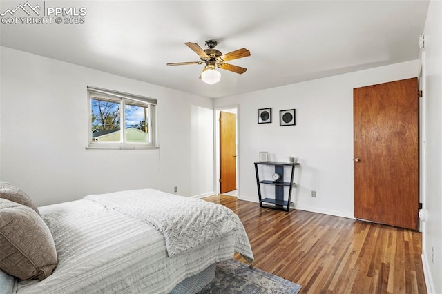bedroom featuring baseboards, a ceiling fan, and wood finished floors