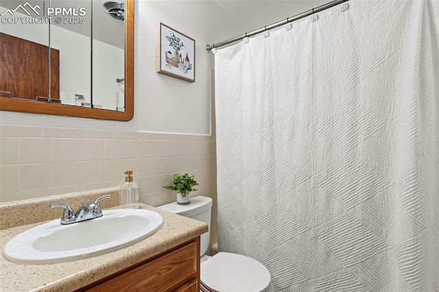 full bath featuring vanity, curtained shower, toilet, and tile walls