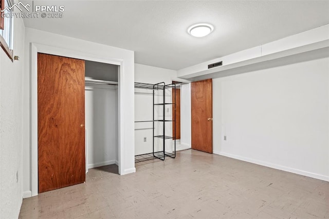 unfurnished bedroom with visible vents, baseboards, tile patterned floors, and a closet