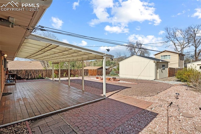 exterior space with a storage unit, a fenced backyard, a wooden deck, and an outbuilding