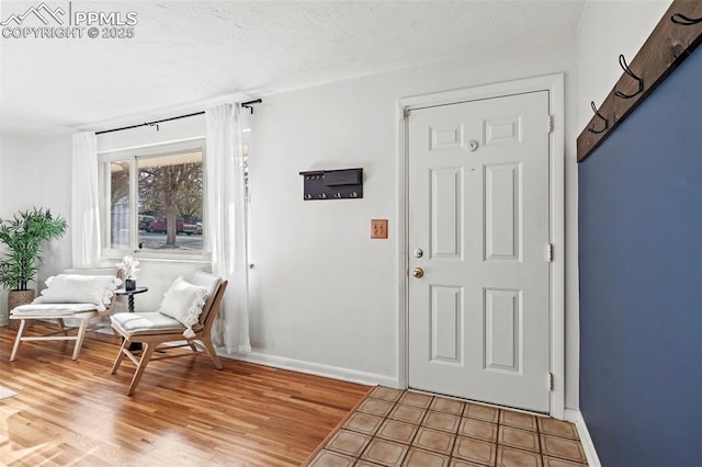 foyer with baseboards and light wood-style floors