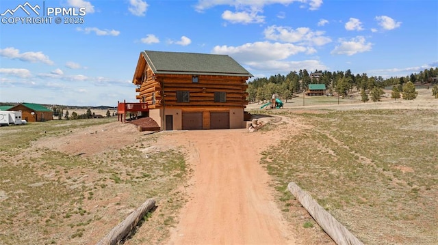 654 High Pasture Rd, Florissant, CO 80816 - view of side of home featuring log siding, driveway, an attached garage, and a wooden deck