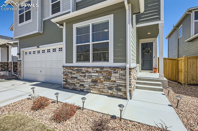7941 Goldenray Pl, Colorado Springs, CO 80908 - view of front of home with fence, an attached garage, driveway, and stone siding