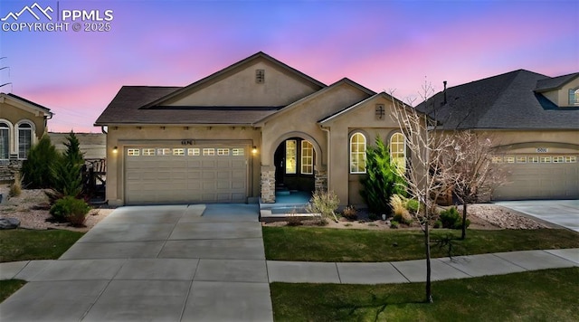 ranch-style house with a garage, concrete driveway, and stucco siding
