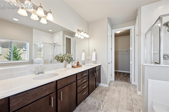 full bath featuring marble finish floor, a sink, double vanity, and a stall shower