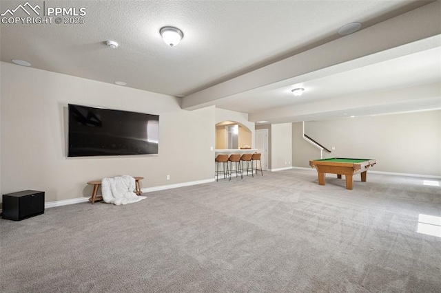 rec room with carpet flooring, arched walkways, a textured ceiling, baseboards, and billiards
