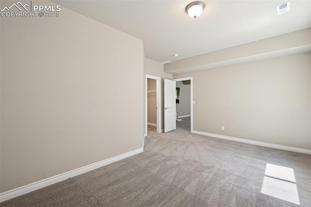 carpeted spare room with visible vents and baseboards
