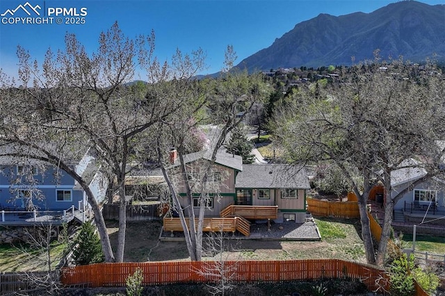 rear view of house featuring a fenced backyard and a deck with mountain view