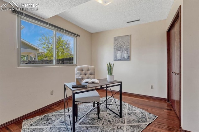office area with wood finished floors, a textured ceiling, baseboards, and visible vents