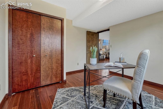 office featuring wood finished floors, a textured ceiling, and baseboards