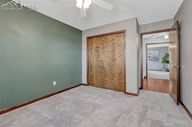 unfurnished bedroom featuring ceiling fan, baseboards, carpet flooring, and a textured ceiling