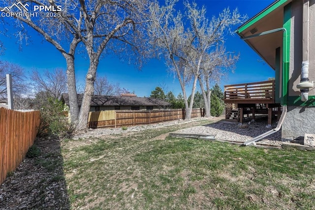 view of yard featuring a fenced backyard, a deck, and stairs