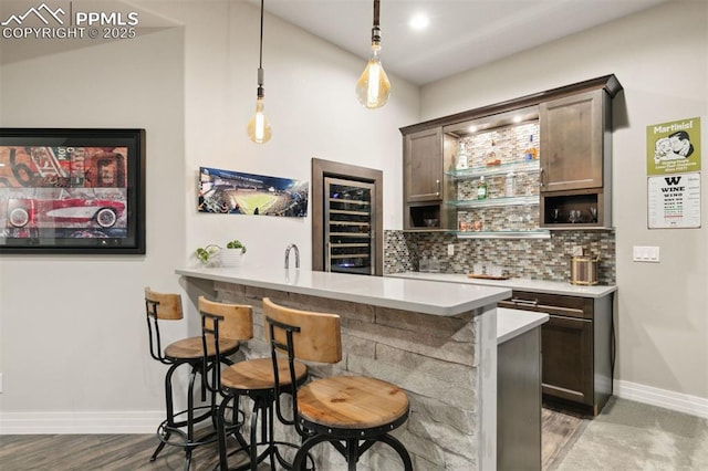 4043 Needles Dr, Colorado Springs, CO 80908 - bar featuring beverage cooler, wet bar, decorative light fixtures, baseboards, and backsplash