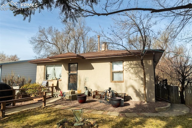 710 S Royer St, Colorado Springs, CO 80903 - rear view of house with stucco siding, a chimney, and fence