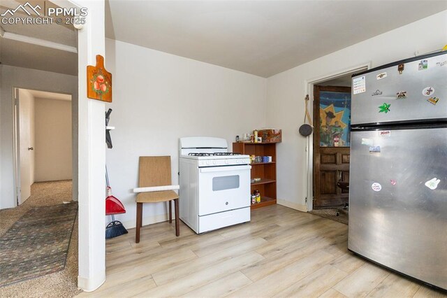 710 S Royer St, Colorado Springs, CO 80903 - kitchen with light wood-style flooring, white gas range, and freestanding refrigerator