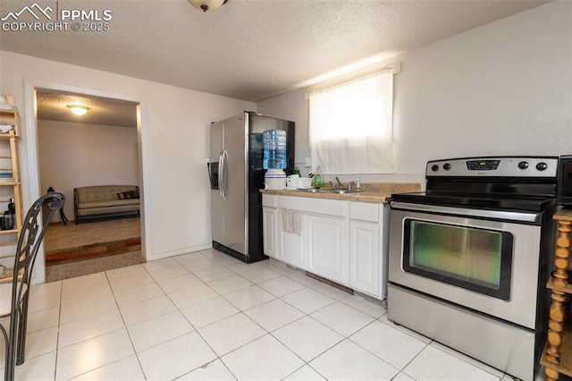 710 S Royer St, Colorado Springs, CO 80903 - kitchen featuring a textured ceiling, appliances with stainless steel finishes, white cabinetry, and a sink