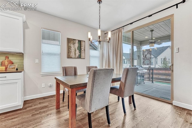 4464 Portillo Pl, Colorado Springs, CO 80924 - dining area featuring light wood-style floors, ceiling fan with notable chandelier, and baseboards