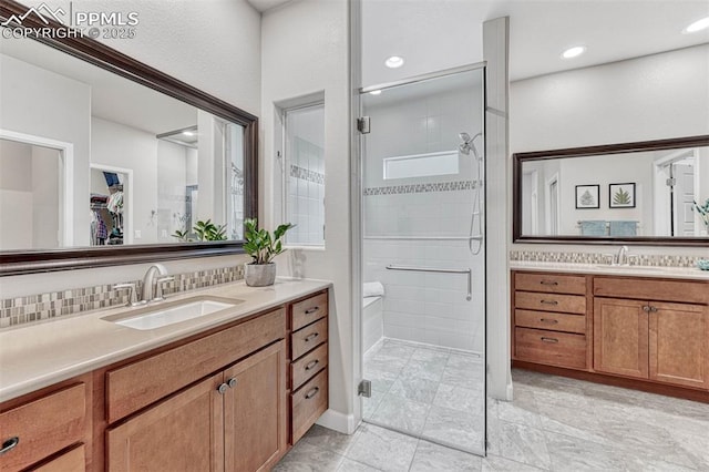 4464 Portillo Pl, Colorado Springs, CO 80924 - bathroom with two vanities, a walk in closet, a shower stall, and a sink