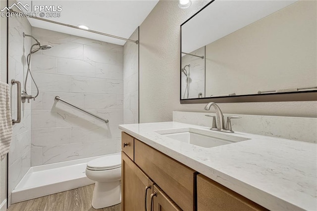 4464 Portillo Pl, Colorado Springs, CO 80924 - bathroom featuring toilet, a tile shower, vanity, and wood finished floors