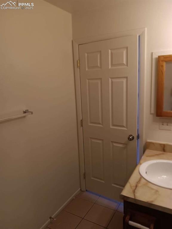 720 E Hills Rd, Colorado Springs, CO 80909 - bathroom with tile patterned floors, baseboards, and vanity