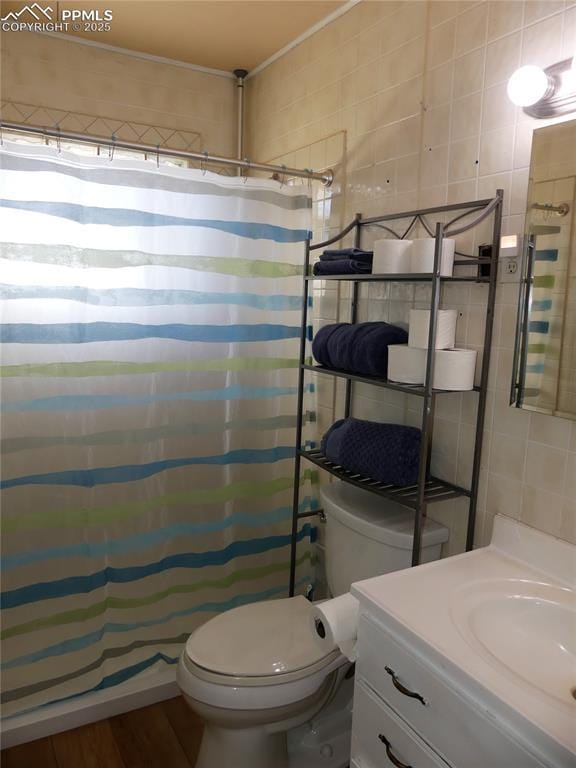 1007 Iowa Ave, Colorado Springs, CO 80909 - full bath featuring tile walls, vanity, curtained shower, and toilet