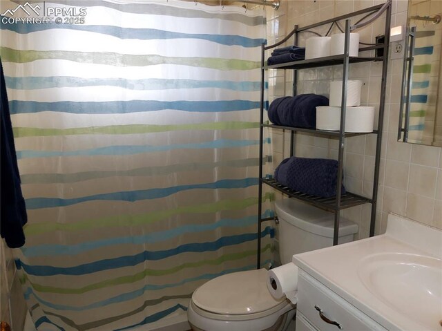1007 Iowa Ave, Colorado Springs, CO 80909 - full bath with toilet, a shower with curtain, vanity, and tile walls