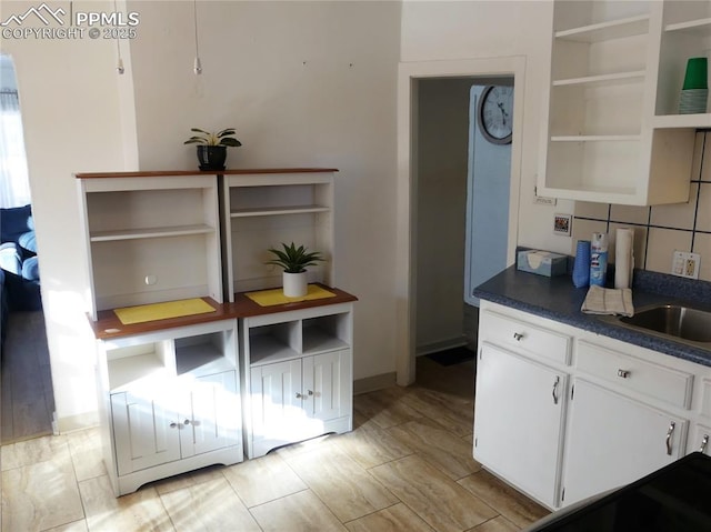 1007 Iowa Ave, Colorado Springs, CO 80909 - kitchen featuring dark countertops, white cabinetry, and open shelves