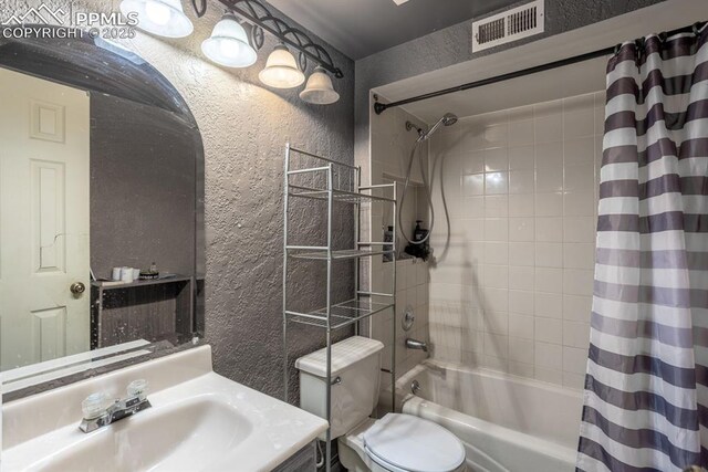 full bathroom featuring shower / bath combo with shower curtain, a textured wall, visible vents, and toilet