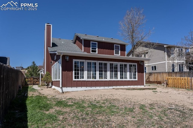 back of house with a chimney and a fenced backyard