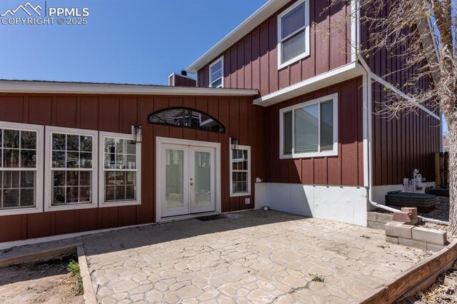 property entrance with board and batten siding, french doors, and a patio area