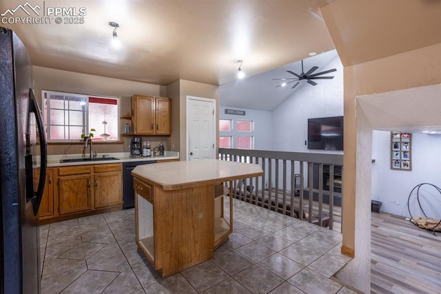 kitchen featuring a ceiling fan, lofted ceiling, light countertops, a sink, and black appliances