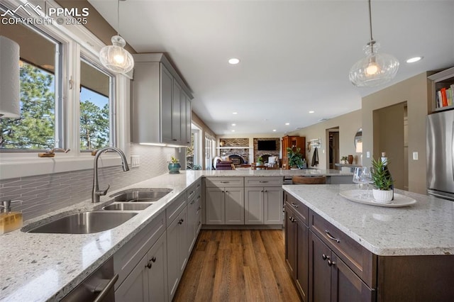 kitchen with a sink, tasteful backsplash, stainless steel appliances, and dark wood-type flooring