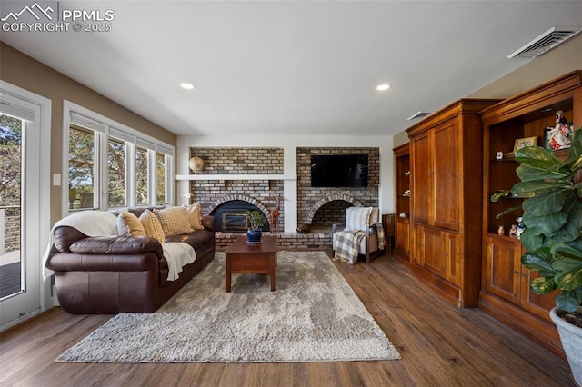 living area with visible vents, recessed lighting, dark wood-style flooring, and a fireplace