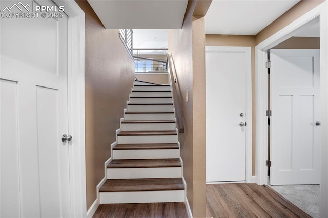 stairway featuring baseboards and wood finished floors