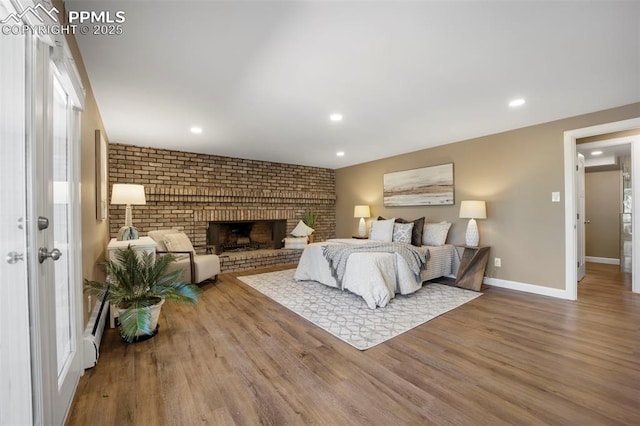 bedroom featuring baseboards, recessed lighting, wood finished floors, and baseboard heating