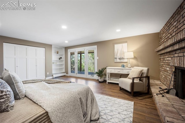 bedroom with dark wood-style flooring, access to exterior, baseboard heating, a fireplace, and recessed lighting