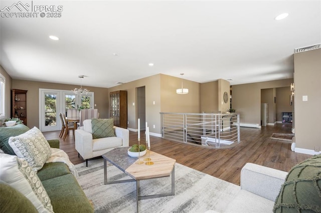 living area with a chandelier, recessed lighting, baseboards, wood finished floors, and visible vents