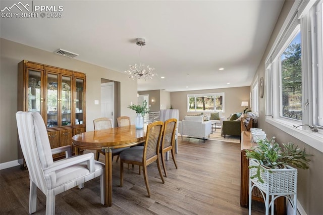 dining area with a chandelier, recessed lighting, baseboards, wood finished floors, and visible vents