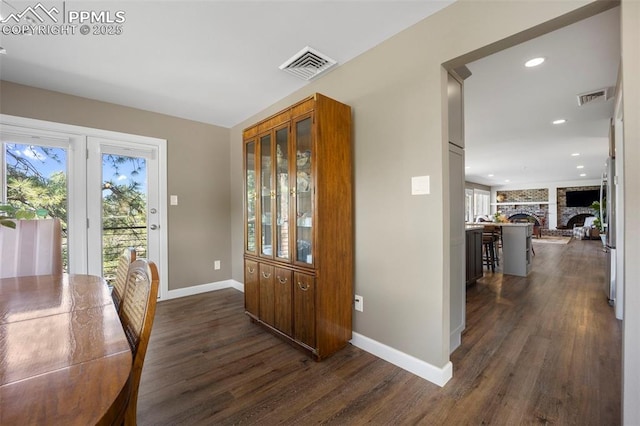 foyer featuring baseboards, visible vents, and dark wood-type flooring